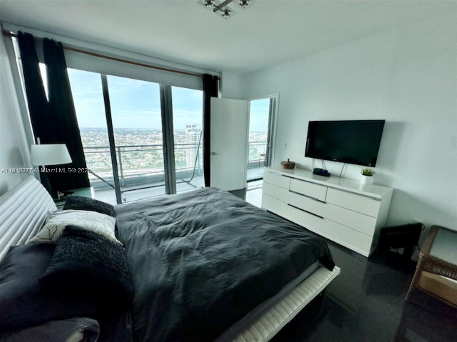92 Southwest 3rd Street, Unit 4107 Miami, FL 33130 - Photo 11 of 30 a bedroom with a bed and flat tv screen on the dresser