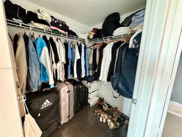 a view of walk in closet with clothes and shoes