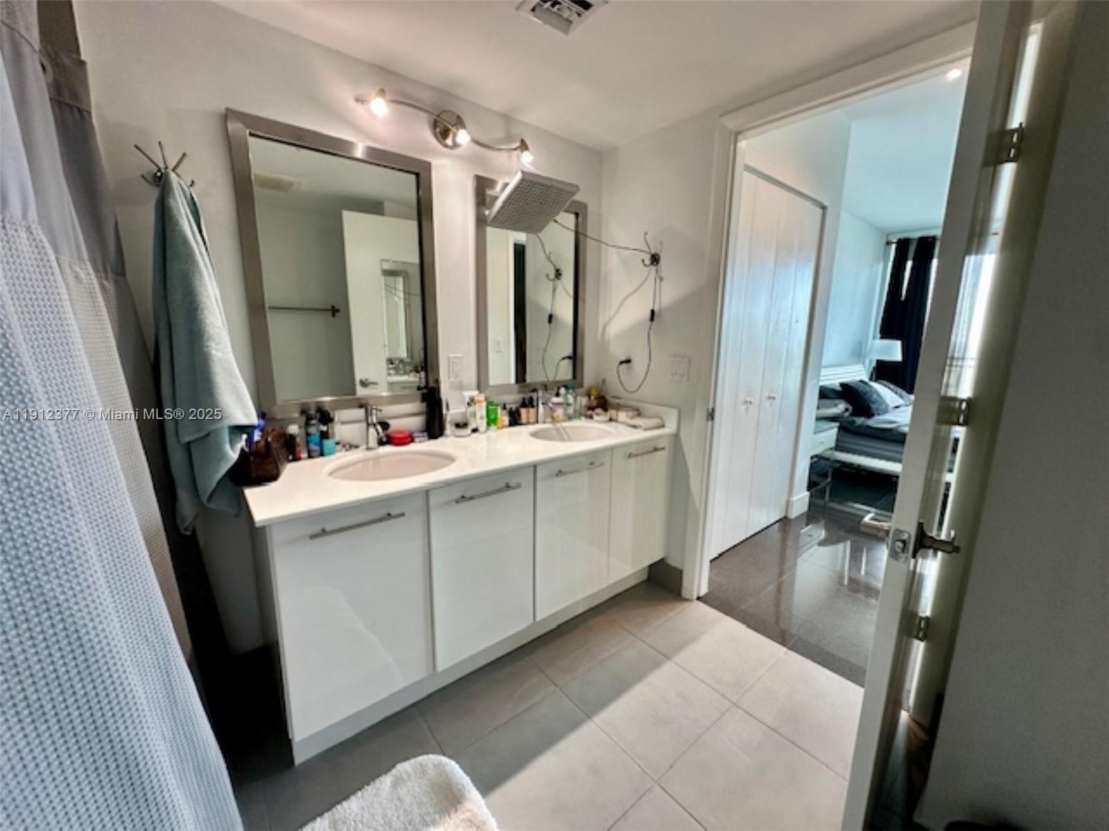 92 Southwest 3rd Street, Unit 4107 Miami, FL 33130 - Photo 15 of 30 a bathroom with a double vanity sink a mirror and a shower