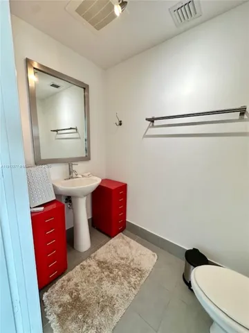 a bathroom with a toilet and a mirror
