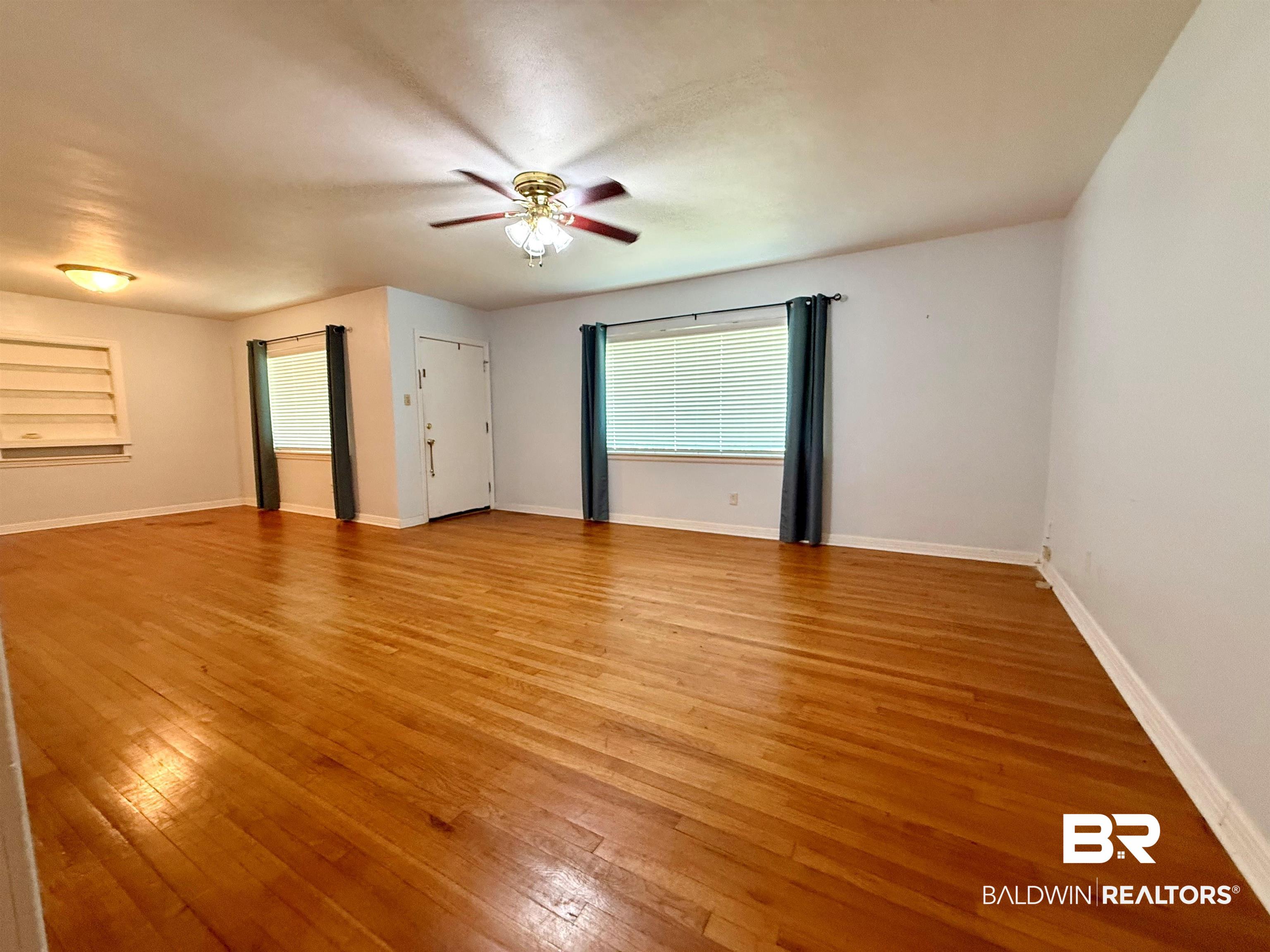403 Sutherland Drive Mobile, AL 36611 - Photo 7 of 8 Spare room with a ceiling fan, light wood-type flooring, and baseboards