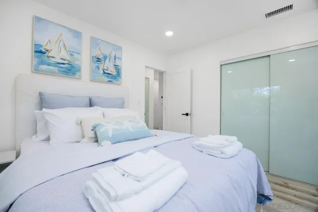 a bedroom with two beds and wooden floor