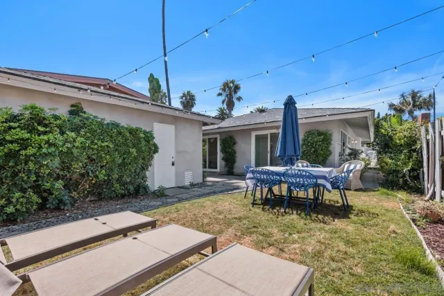 a view of a patio with table and chairs potted plants and wooden fence