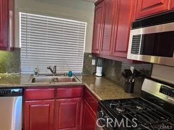 a kitchen with a sink a stove and cabinets