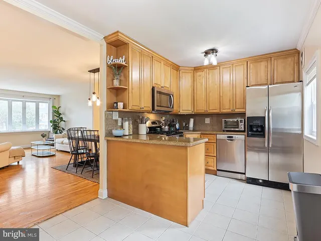 a kitchen with stainless steel appliances granite countertop a refrigerator a sink a stove and white cabinets