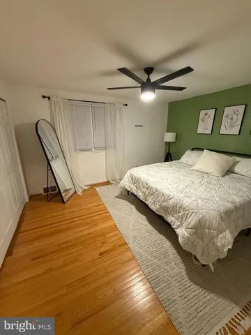 a bedroom with a bed and a ceiling fan