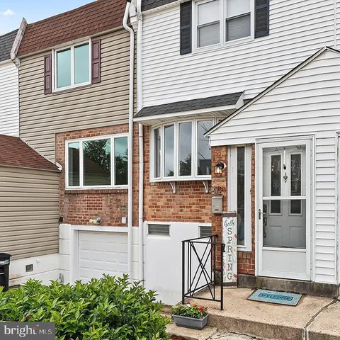 a view of a white house with large windows and plants