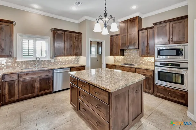 a kitchen with kitchen island granite countertop stainless steel appliances and cabinets