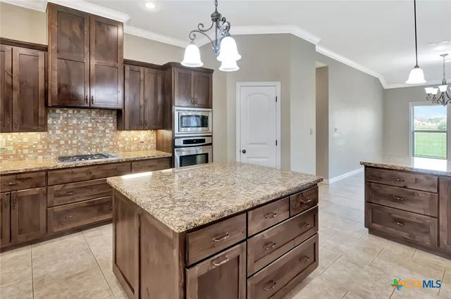 a kitchen with kitchen island granite countertop wooden cabinets and refrigerator