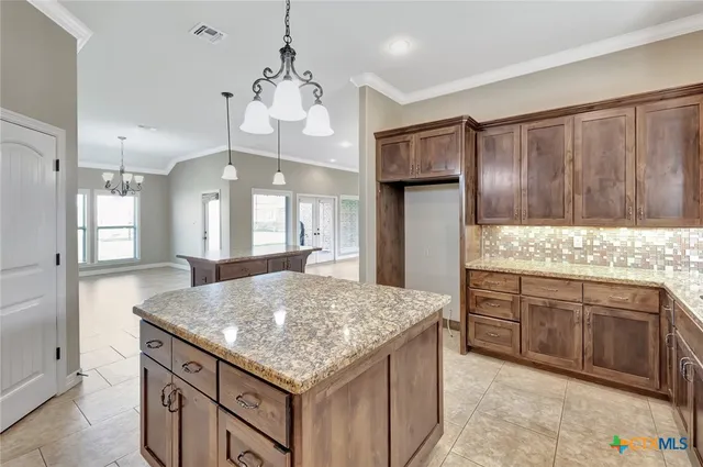 a kitchen with stainless steel appliances granite countertop wooden cabinets a center island and a window