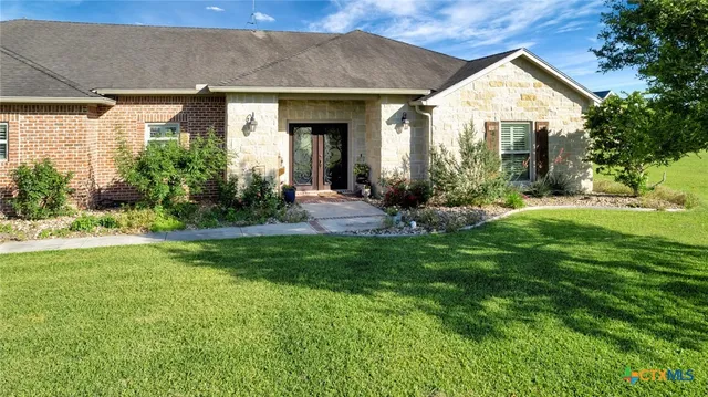a view of a house with a yard and plants