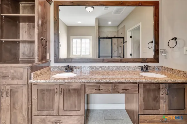 a bathroom with a granite countertop sink and a mirror