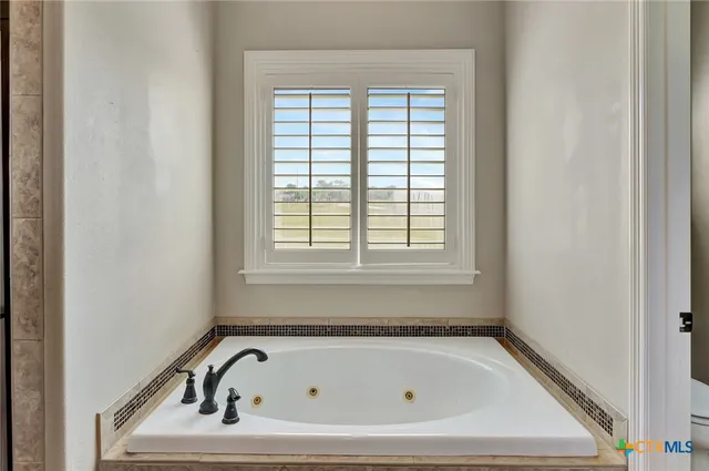 a bathroom with a tub and a window