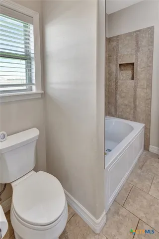 a white toilet sitting next to a bath tub