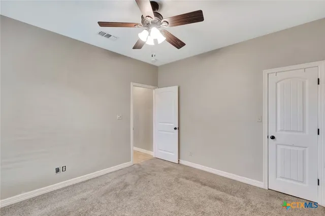 an empty room with fan and a ceiling fan