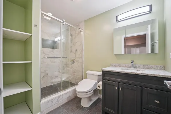 a bathroom with a sink a toilet and shower