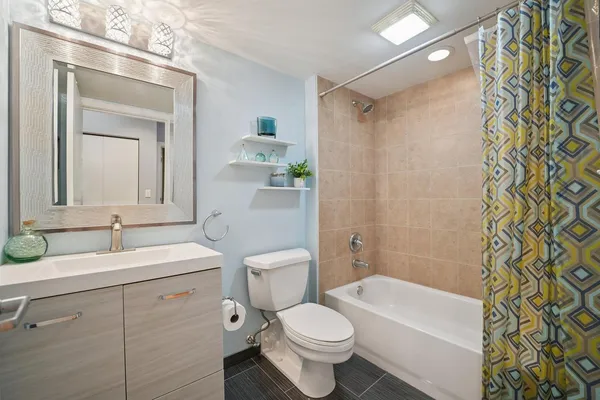 a bathroom with a sink a toilet and shower