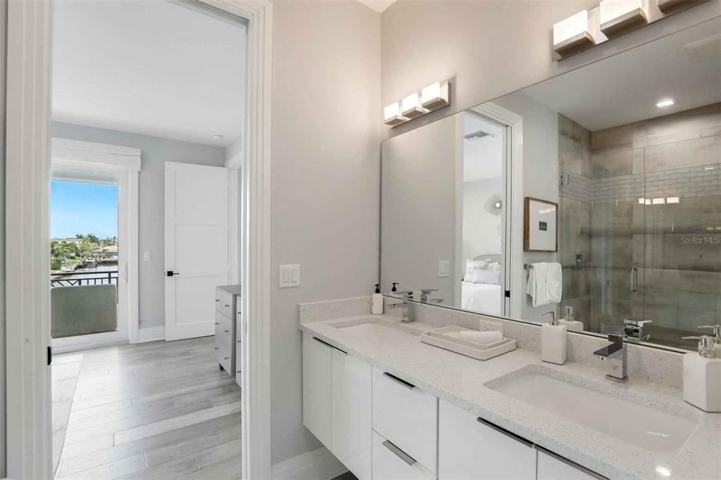 1608 Windmill Avenue Marco Island, FL 34145 - Photo 16 of 34 a bathroom with a double vanity sink a mirror and a shower