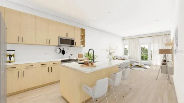 a kitchen with stainless steel appliances granite countertop a stove top oven a sink a dining table and chairs with wooden floor