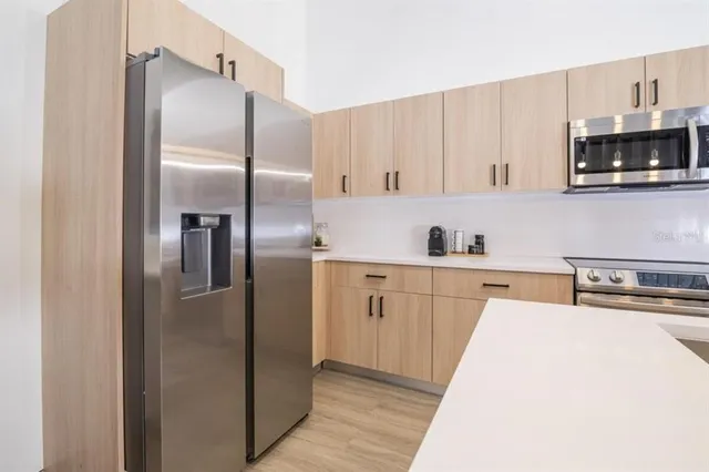 a kitchen with stainless steel appliances kitchen island a refrigerator sink and microwave