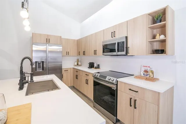 a kitchen with stainless steel appliances granite countertop a stove a sink and a microwave