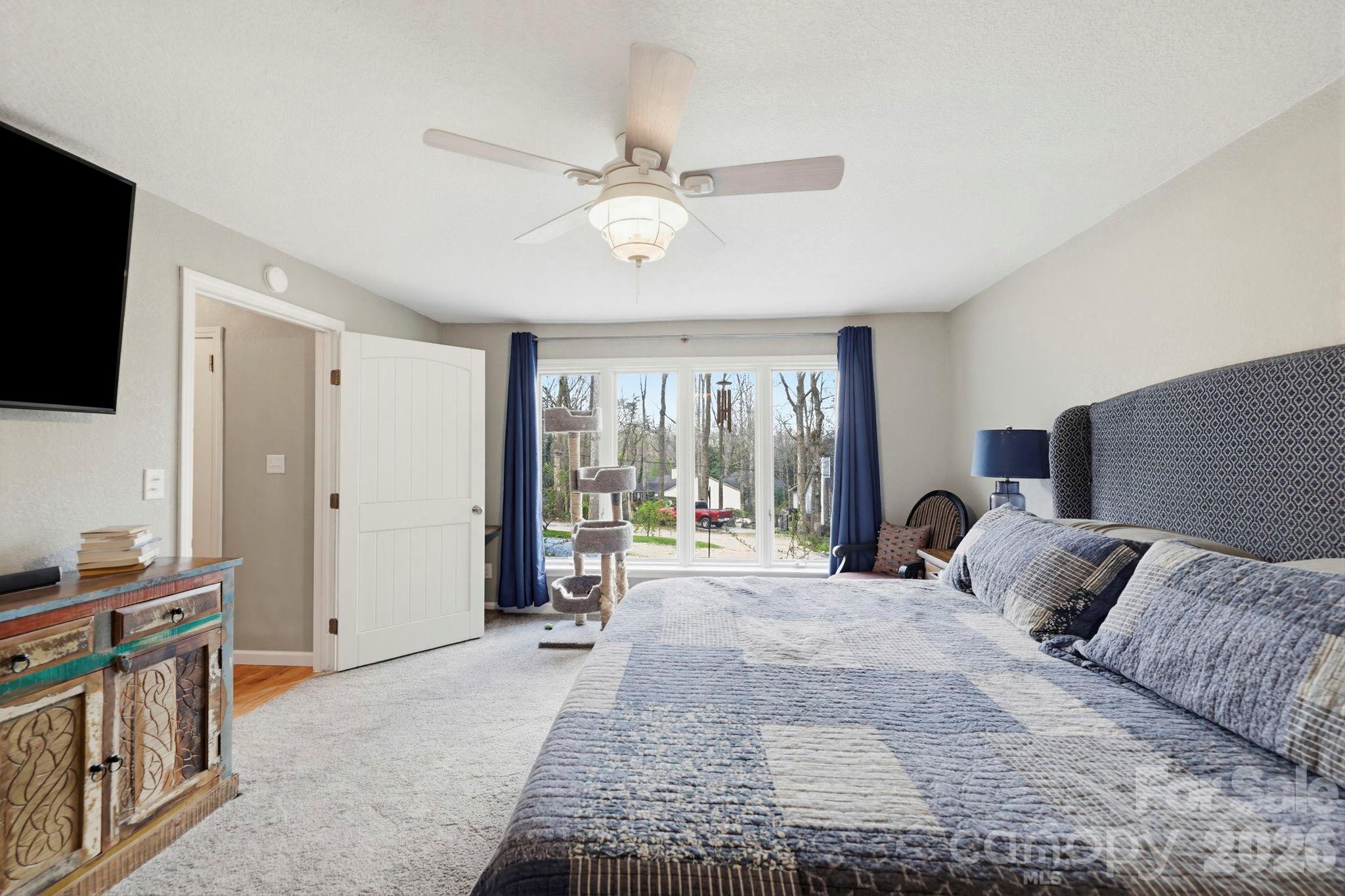 27 Spring Hill Circle Arden, NC 28704 - Photo 19 of 47 a spacious bedroom with a large bed and a flat tv screen on dresser