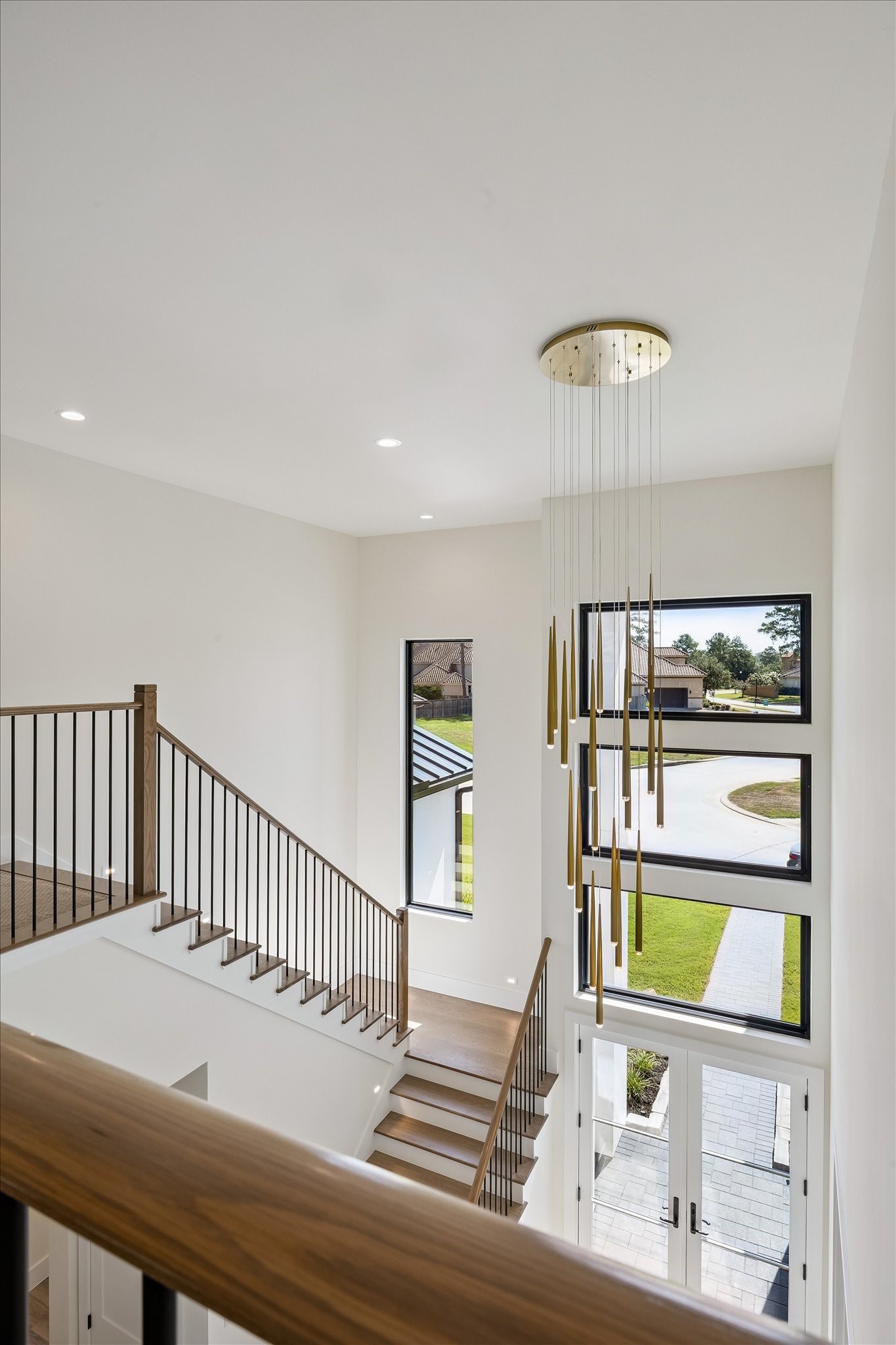 65 Shadow Creek Ridge Drive Spring, TX 77389 - Photo 29 of 41 Dramatic two-story foyer showcases a modern chandelier, floating stairs, and expansive picture windows.
