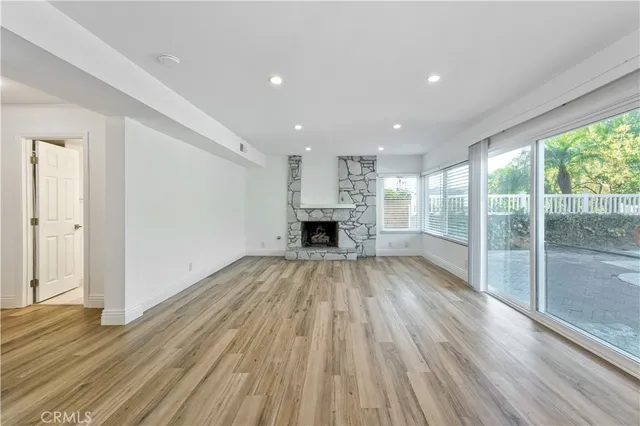 a view of empty room with wooden floor and fireplace