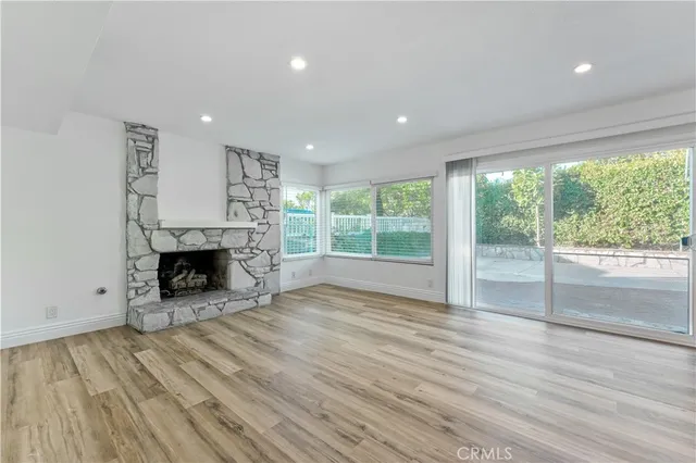 a view of an empty room with a fireplace and a window
