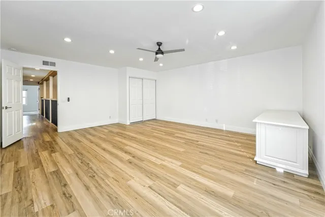 a big room with wooden floor and a ceiling fan