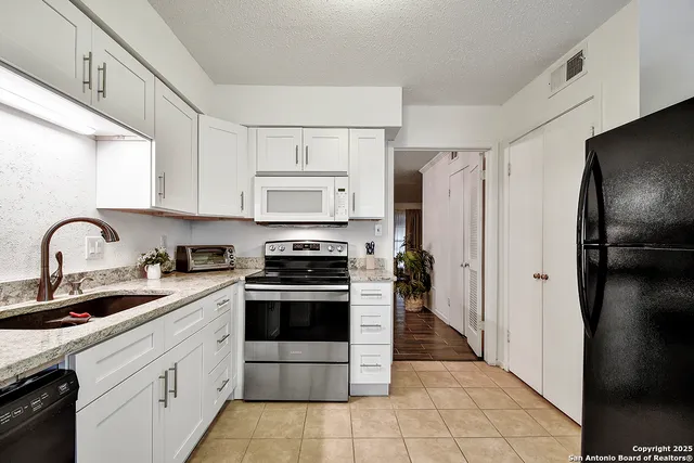 a kitchen with stainless steel appliances a refrigerator sink and cabinets