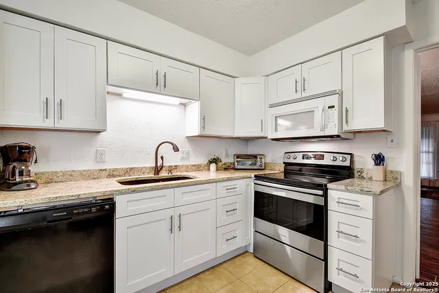 a kitchen with cabinets stainless steel appliances and a sink