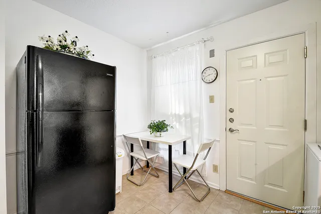 a view of a hallway that has a dining table and a chandelier
