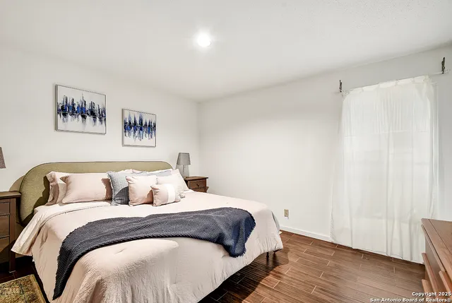 a bedroom with a large bed and wooden floor