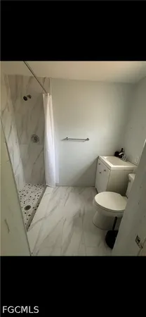 a bathroom with a toilet and a shower