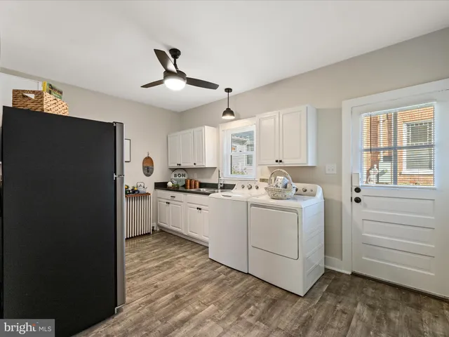 a kitchen with a refrigerator and white cabinets