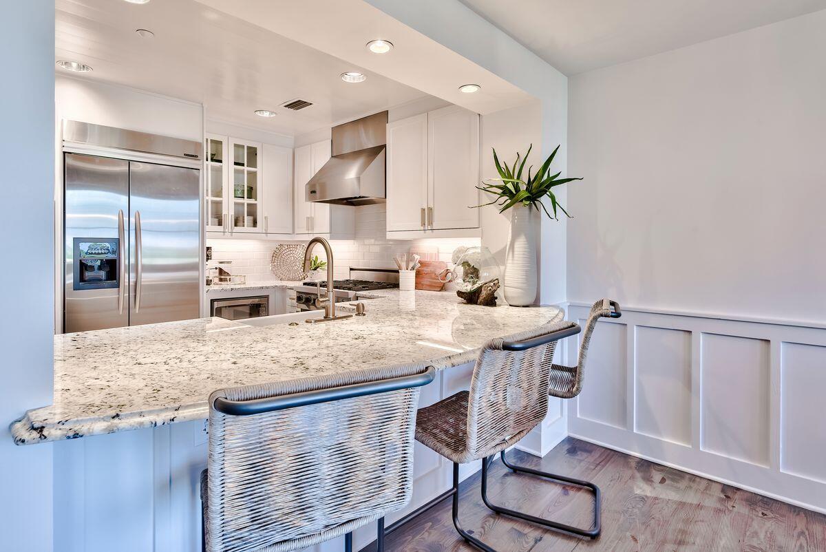 337 Bridge Lane, Unit 102B Inlet Beach, FL 32461 - Photo 21 of 50 a kitchen with a table chairs refrigerator and cabinets