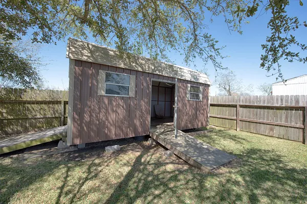 a view of a barn house next to a yard with wooden fence