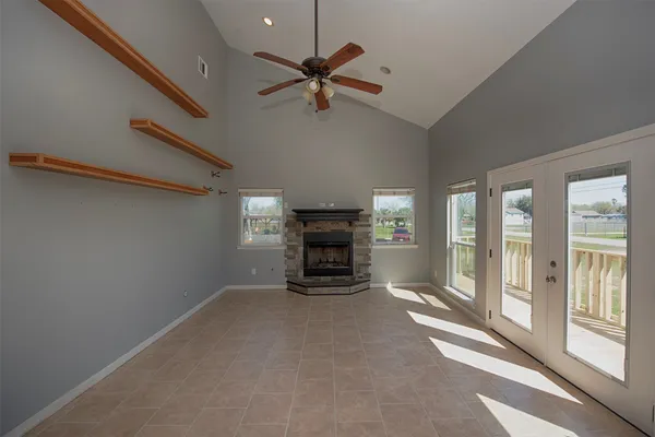 a view of an empty room with a fireplace and a window