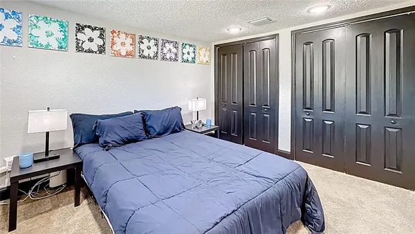 a bedroom with a bed table and a dresser