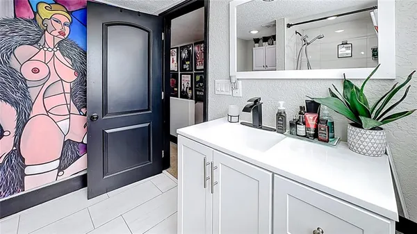 a bathroom with a sink a mirror and a potted plant