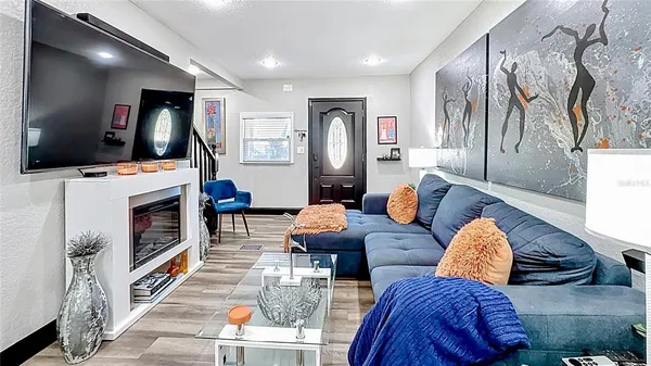 a living room with furniture a flat screen tv and a fireplace