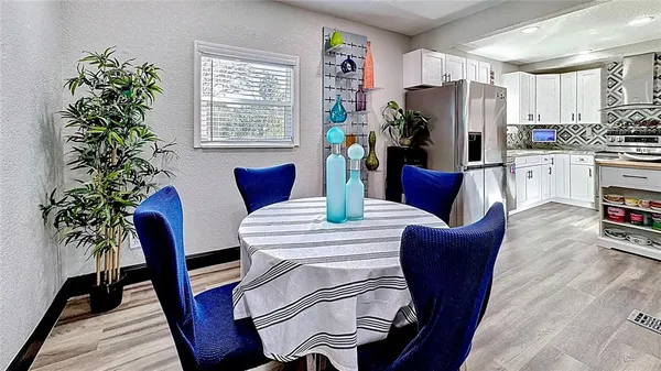 a dinning room with furniture a potted plant and wooden floor