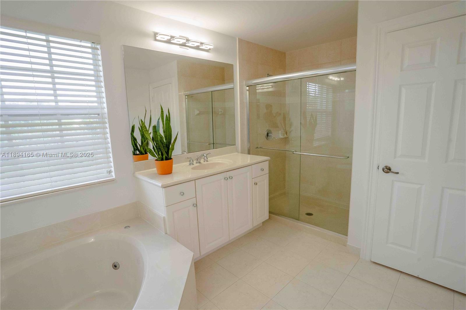4537 Southwest 183rd Avenue Miramar, FL 33029 - Photo 17 of 46 a bathroom with a sink a granite tub shower and a mirror
