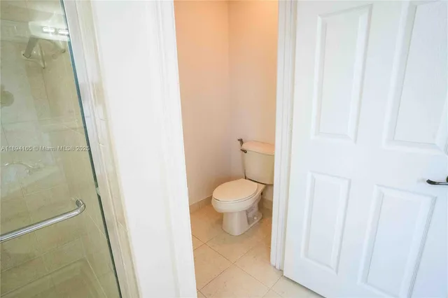 a bathroom with a granite countertop toilet and a sink