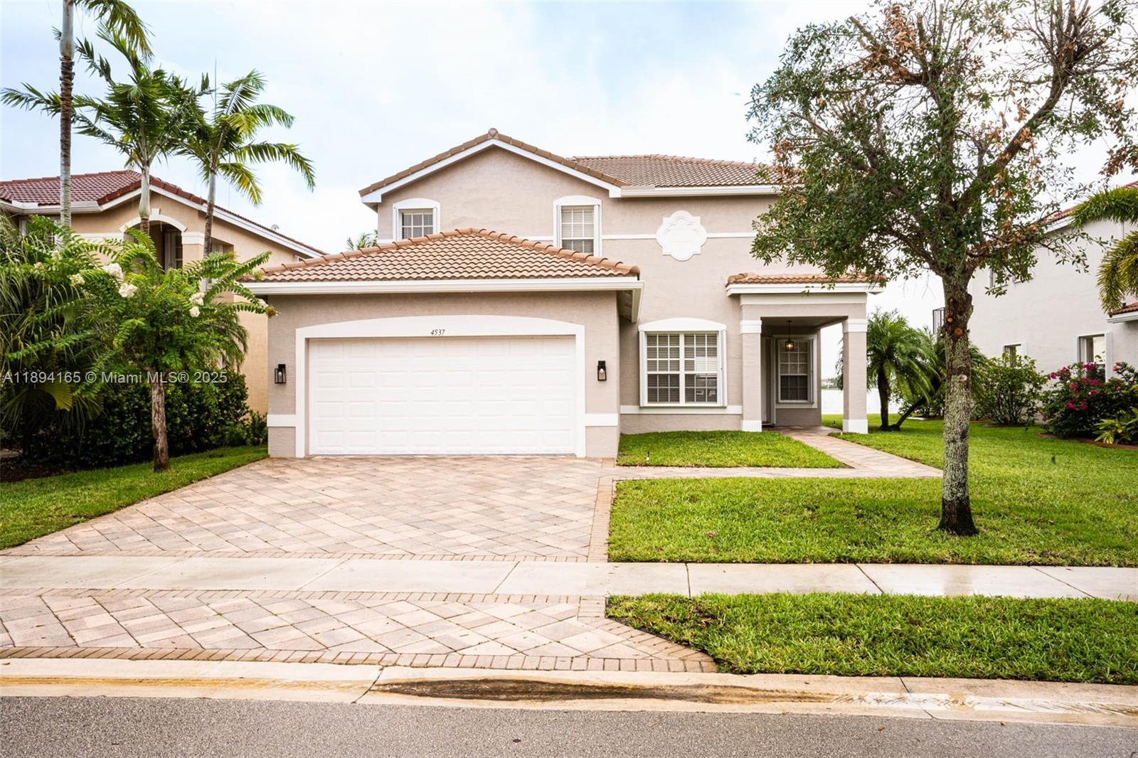 4537 Southwest 183rd Avenue Miramar, FL 33029 - Photo 2 of 46 a front view of a house with a yard and garage