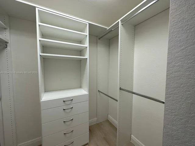 a view of walk in closet with empty racks