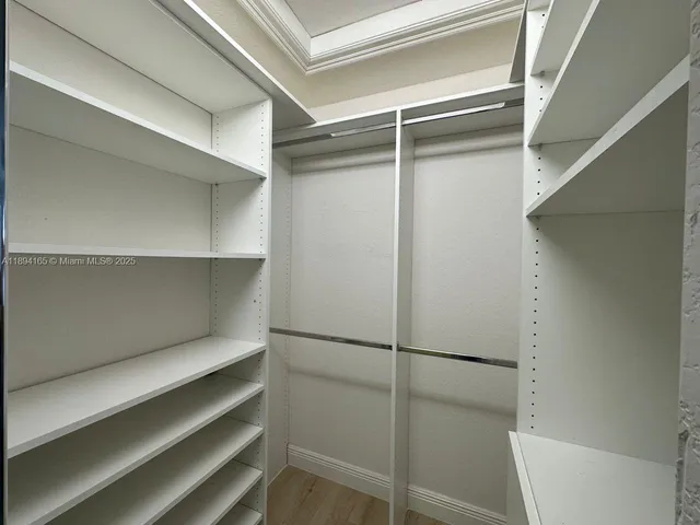a view of walk in closet with empty racks