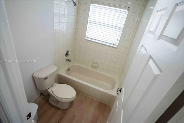 a white toilet sitting next to a bath tub