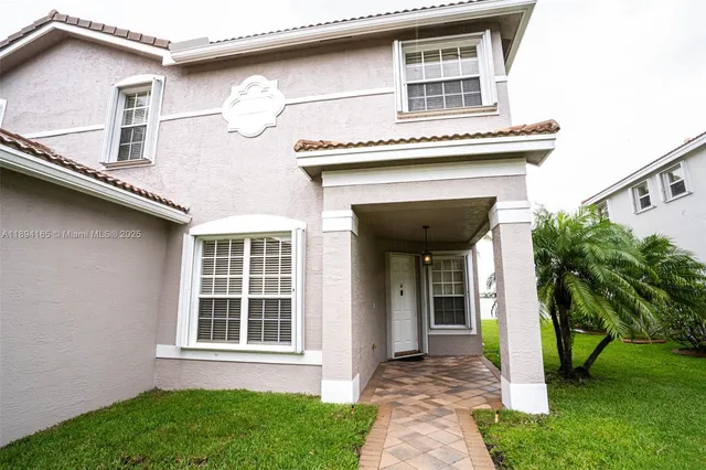 a front view of a house with a garden